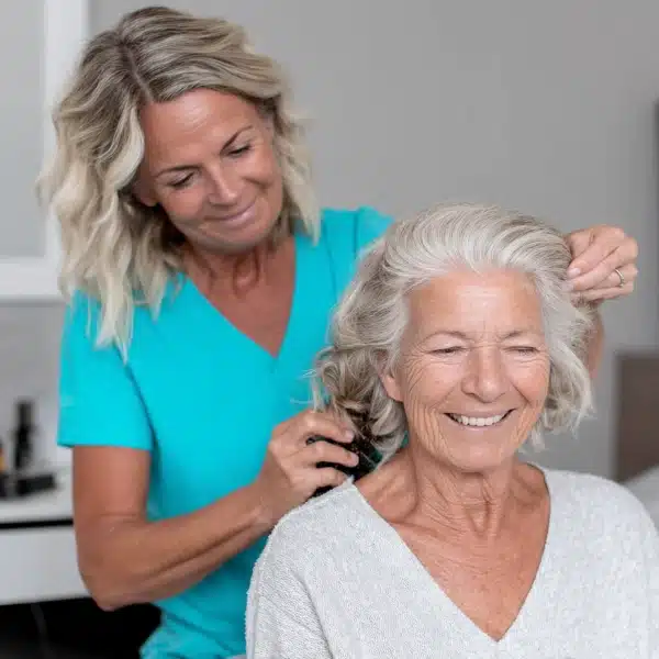 Pflegekraft hilft Patientin während der Grundpflege bei der Frisur